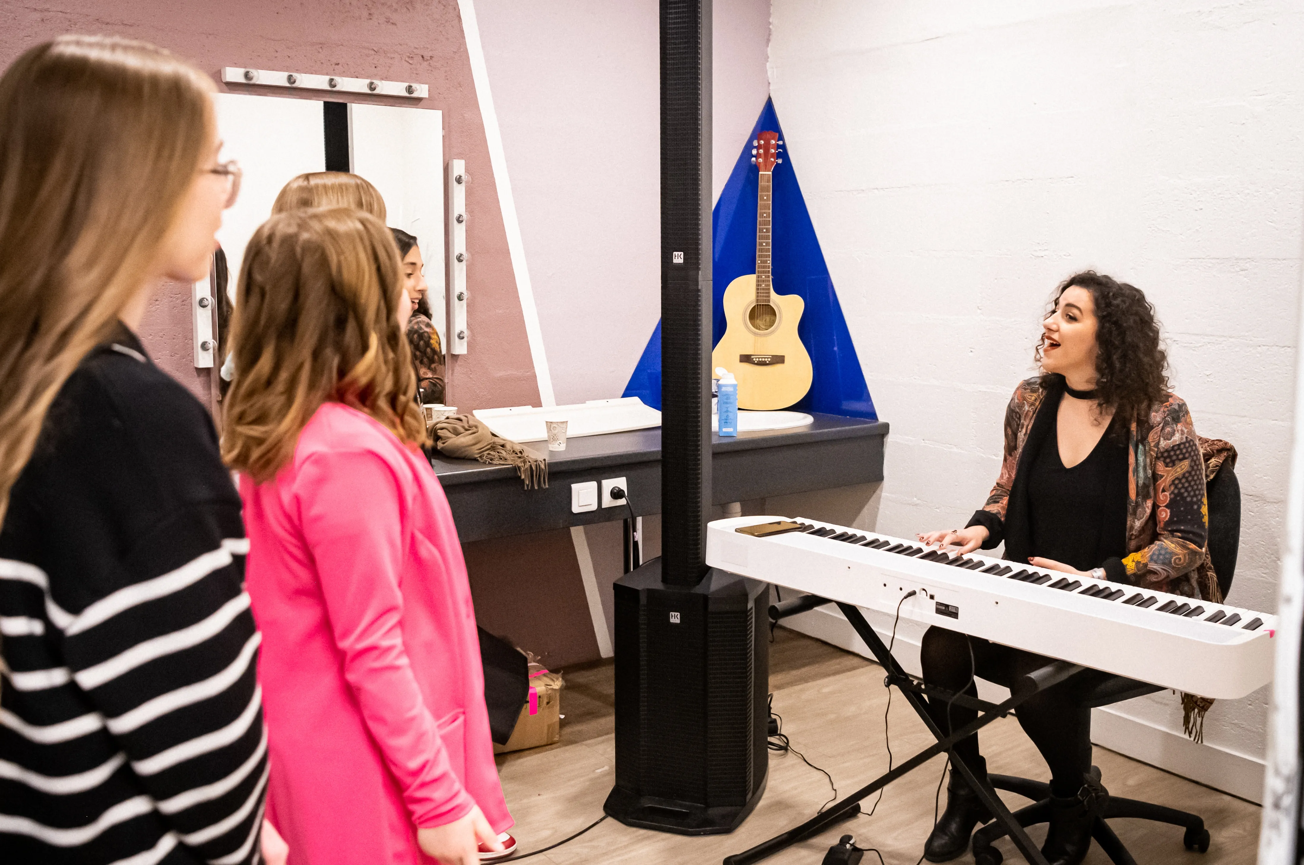 Margaux enseigne des cours de chant à l'aide d'un piano